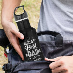 Botella De Agua Feliz Día del Padre Diversión al mejor nombre del<br><div class="desc">Un regalo divertido y personalizado para el mejor padre del mundo. El diseño presenta un divertido diseño de tipografía "El mejor papá del mundo" y está personalizado con el nombre de su hijo y el año de nacimiento de su padre. Hace el regalo perfecto para tu padre especial para el...</div>