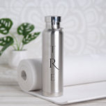 Botella De Agua Monograma de moda sobre plata<br><div class="desc">El monograma vertical negro de moda sobre plata presenta una inicial más decorativa en el centro. Reemplace las 3 iniciales por las suyas en la barra lateral. En la barra lateral se pueden encontrar otros colores y estilos para botellas de agua. Copyright © Claire E. Skinner. Todos Los Derechos Reservados....</div>