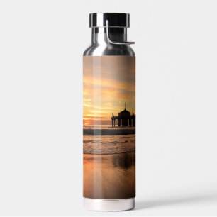 Botella De Agua Muelle sobre la puesta de sol en la playa del océa