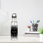 Botella De Agua Purpurina de plata negra gotea nombre de monograma<br><div class="desc">Un elegante fondo negro con elegantes goteos en purpurina plateado falso,  pinturas de goteo. Personaliza y agrega tu nombre. El nombre está escrito con un guión de estilo con letras a mano blanca.</div>
