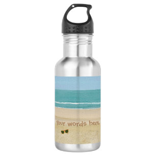 Botellas de agua del océano de arena y gafas de so