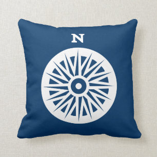 brújula náutica blanco sobre almohada verde azulad