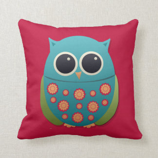 Búho azul y verde lindo sobre almohada roja