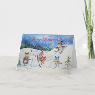 Búhos del navidad que juegan en nieve