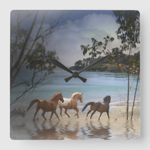 Caballos corriendo en el reloj de la playa