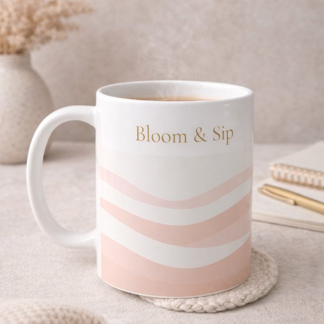 Café Taza clásica blanca con onda de rubor, 11 oz (White ceramic wrapped in blush ripples with gold serif detail for calm morning routines.)