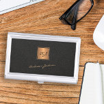Caja Para Tarjetas De Visita Elegante nombre de guión monocromático de oro negr<br><div class="desc">Funda de tarjetas de visita en oro monogramado de lujo de diseño con una plaza de imitación de oro sobre un elegante fondo de cuero negro (impreso).             Personalízalo con el nombre de la firma del guión blanco y las iniciales del nombre del monograma.</div>