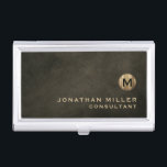 Caja Para Tarjetas De Visita Monograma de oro negro de lujo mínimo<br><div class="desc">Diseño de monograma minimalista con medallón de monograma de oro metálico cepillado con nombre y título personalizados o texto personalizado debajo en tipografía clásica de bloques sobre un fondo texturado en tonos de castaño negro. Personalice el producto para su personalizado.</div>