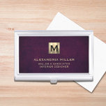 Caja Para Tarjetas De Visita Monograma elegante de oro de cuero<br><div class="desc">Diseño lujoso y sencillo con medallón inicial de oro metálico cepillado con nombre personalizado,  título,  nombre de la empresa o texto personalizado abajo en tipografía clásica de bloques sobre un fondo texturado de cuero púrpura. Personalice el producto para su personalizado.</div>