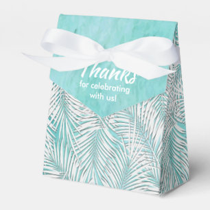 Cajas de regalos de fiesta con palmas blancas sobr