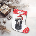 Calcetín Navideño Grande Labrador negro recuperar Santa Hat<br><div class="desc">La parte delantera de esta reserva de vacaciones muestra una imagen de un majestuoso Labrador negro que lleva puesto un sombrero Santa. La imagen se coloca sobre un fondo blanco, y el pie y el borde superior son un patrón de copo de nieve rojo y blanco. En el borde superior...</div>