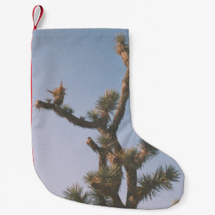 CALCETÍN NAVIDEÑO PEQUEÑO ÁRBOL VERDE Y MARRÓN BAJO CIELO AZUL