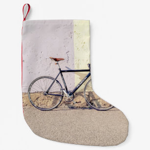 CALCETÍN NAVIDEÑO PEQUEÑO BICICLETA NEGRA Y GRIS EN MURO BLANCO