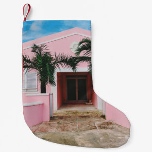 CALCETÍN NAVIDEÑO PEQUEÑO CASA DE CONCRETO ROSA Y BLANCA CERCA DE ÁRBOLES VE