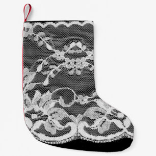 Calcetín Navideño Pequeño Encaje floral blanco sobre un fondo negro.