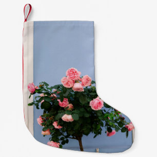 Calcetín Navideño Pequeño Flores rojas con hojas verdes en la pared azul