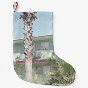CALCETÍN NAVIDEÑO PEQUEÑO PALM TREE CERCA DE LA CASA DE CONCRETOS BLANCOS