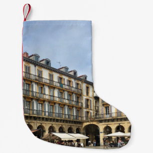 CALCETÍN NAVIDEÑO PEQUEÑO PERSONAS CAMINANDO CERCA DEL EDIFICIO BEIGE CONCRE