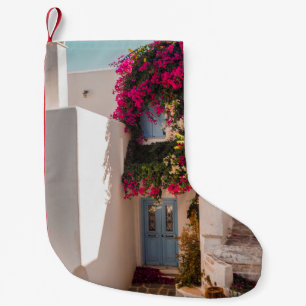 CALCETÍN NAVIDEÑO PEQUEÑO PLANTA ROSA Y VERDE EN LA PARED DE CONCRETO BLANCO