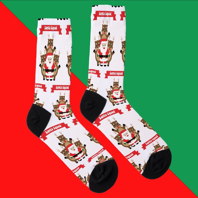 Calcetines Patrón divertido de renos de Santa Squad (A pair of socks with a pattern of santa and reindeer with a banner that reads Santa Squad.)