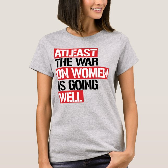 CAMISETA AL MENOS LA GUERRA CONTRA LAS MUJERES VA BIEN (Anverso)