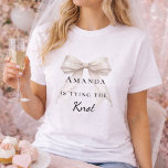 Camiseta Anudando el nudo perlas de arco de marfil Despedid<br><div class="desc">Eleva tus eventos nupciales con esta sofisticada colección de fiesta temática coquette. Cada pieza muestra un arco de marfil de alta fidelidad combinado con delicados acentos de perlas y tipografía atemporal. Este conjunto es perfecto para la novia moderna que quiere una apariencia coherente para su viaje de despedida de soltera...</div>