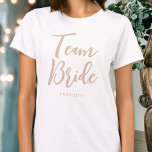 Camiseta Boda de novia personalizado Beige-Blanco<br><div class="desc">¡Celebra tu brida con esta camiseta boda personalizada! Las palabras "Team Bride" se escriben en un tipo de letra de guión moderno y, a continuación, puede agregar un nombre personalizado, una fecha de boda, una ubicación u otro texto. ¡Un regalo encantador para una fiesta de soltera, una ducha de boda...</div>