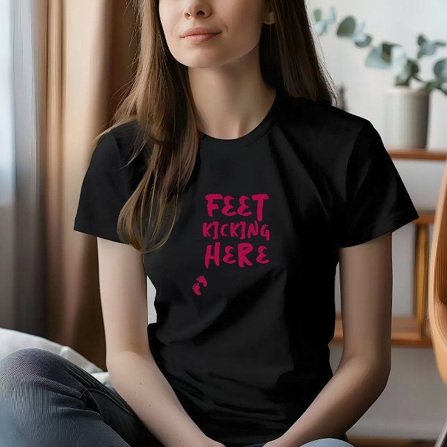 Camiseta burdeos de huellas dactilares de embarazo (Pregnancy T-shirt with burgundy fingerprint design and the playful phrase "Feet Kicking here".)