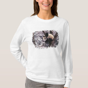 Camiseta Cachorro de panda jugando en un árbol cubierto de