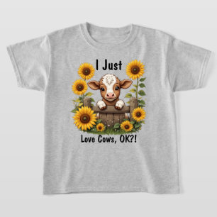Camiseta Calf Peeando sobre la valla rodeada de girasoles