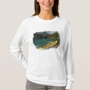 Camiseta Canoa estacionada en un muelle a lo largo del lago