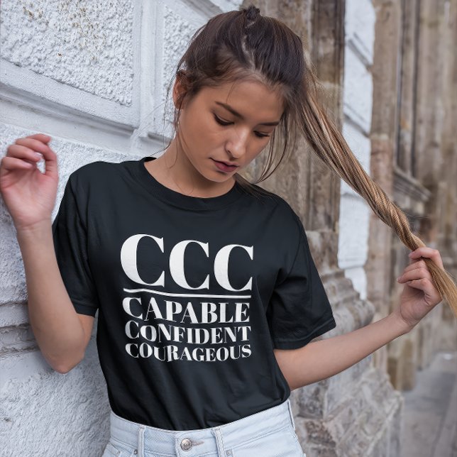 Camiseta CCC - Capaz, Confiada, Valiente (Young woman wears a "CCC:Capable, Confident, Courageous" black t-shirt.)