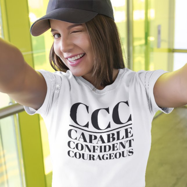 Camiseta CCC - Capaz, Confiada, Valiente (Young woman wears a "CCC:Capable, Confident, Courageous" white t-shirt.)