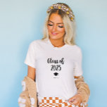 Camiseta Clase simple y de Moda de 2023 con tapón y tacón<br><div class="desc">Esta camisa en blanco y negro de moda muestra la moderna y moderna tipografía de escritura que dice "clase del 2023". También hay una imagen de una gorra de graduación y un tassel.</div>