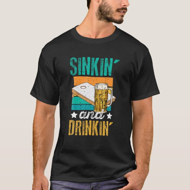 Camiseta Cómico Sinkin' Y Bebe De Cornhole Beer (Anverso)