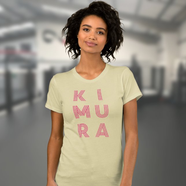 Camiseta Crema Jiu Jitsu de una mujer de Kimura (Kimura BJJ t-shirt in cream worn by a female model in the gym.)