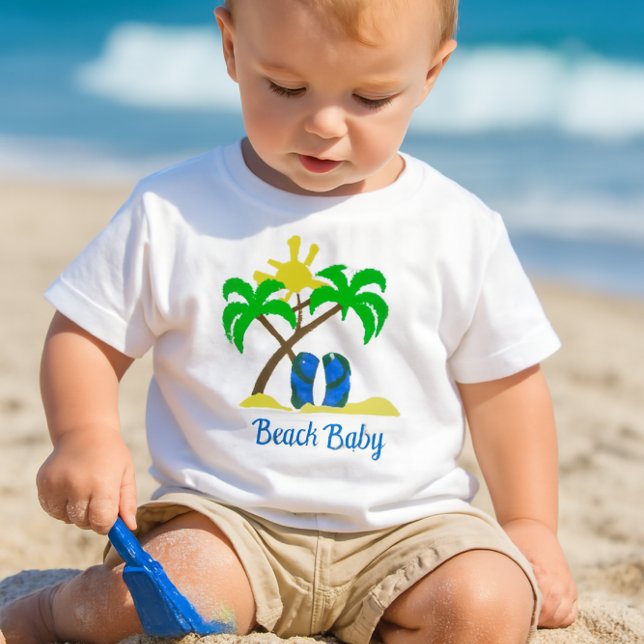Camiseta De Bebé Bebé lindo de playa  (a toddler playing in the sand with a small blue shovel, wearing a white crewneck short-sleeve tee-)