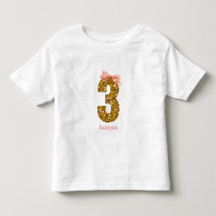 Camiseta De Bebé Purpurina de Oro de Bow Rosado Tres Años