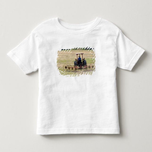 Camiseta De Bebé Un joven muchacho conduciendo un tractor cosechand (Anverso)