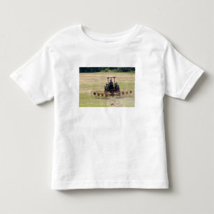 Camiseta De Bebé Un joven muchacho conduciendo un tractor cosechand