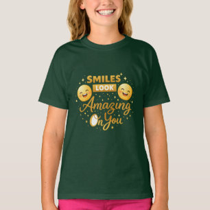 Camiseta de niña dorada con el mensaje “Smiles Loo