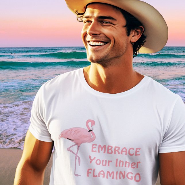 Camiseta Divertida cita de Abrazar tu Flamenco Interior (handsome fit young male model wearing pink flamingo t-shirt at beach)