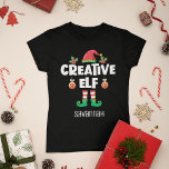 Camiseta Divertido elfo creativo con familia de Navidades d<br><div class="desc">Perfecto para cualquier reunión familiar de Navidades, esta divertida camiseta presenta un gorra elfo lindo y piernas pequeñas, con la leyenda "elfo creativo" en un estilo contemporáneo blanco de mayúsculas y minúsculas. Esta divertida e irónica camiseta de elfo, que forma parte de una colección de prendas de vestir de elfos...</div>