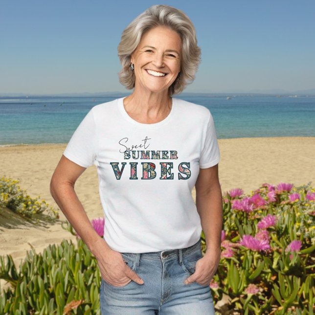 Camiseta Dulces vibraciones de verano - Tipografía floral ("Sweet Summer Vibes" floral typography tshirt, in a beach setting. This model is #generativeai)