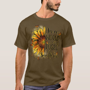 Camiseta En un mundo lleno de rosas sea un girasol