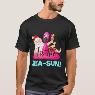 Camiseta Flotador de flamenco de Santa Claus Es la Navidad 