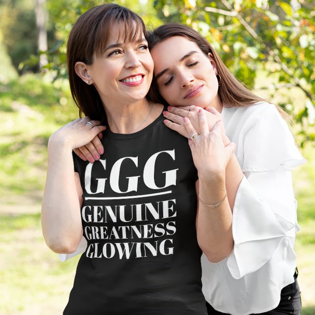 Camiseta GGG- Genuino, Grandeza, Brillante (A daughter holds her mother. The mother wears a "GGG: Genuine, Greatness Glowing" black t-shirt.)