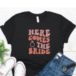 Camiseta Graciosa Bachelorette Bride T Shirt<br><div class="desc">Una linda y divertida soltera en la camiseta para la novia. Texto simple que dice Aquí viene la novia con letras rosas y un anillo rosado.</div>