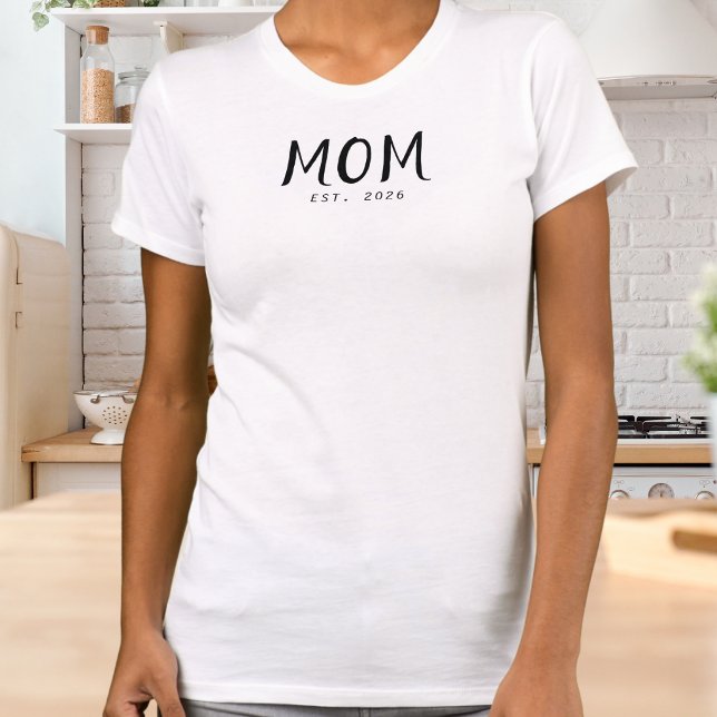 Camiseta Guion negro establecido mamá (A white t-shirt with "Mom Est. 2026" design in black lettering)