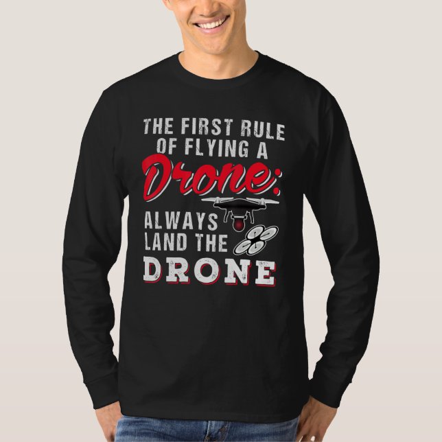 Camiseta La Primera Regla De Volar Un Dron Siempre Lleva A  (Anverso)